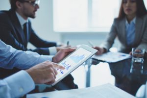 Image of businessperson pointing at document in touchpad at meeting